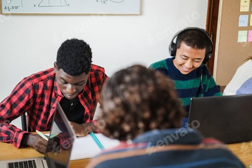 Preview: Multiracial students using laptop computers while studying together at school