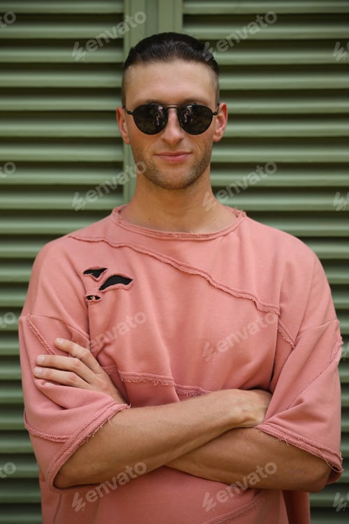 Preview: Handsome young man in stylish sunglasses near shutters