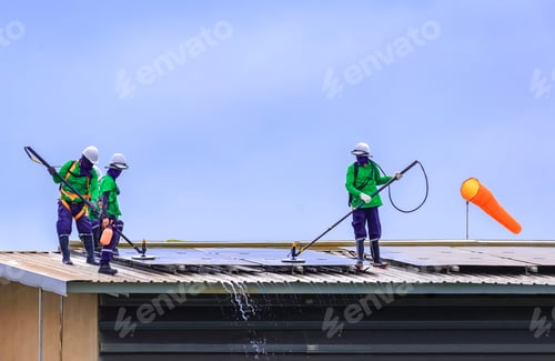 Preview: Group of professional cleaning service workers clean the solar panels on industrial building roof