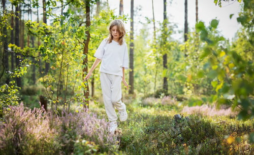 Preview: A young girl exploring a lush forest during summer surrounded by vibrant greenery