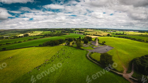 Preview: Aerial drone view of the Cappagh Parish Church in Northern Ireland under a blue cloudy sky