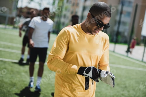 Preview: portrait of african american goalkeeper in sunglasses on soccer pitch