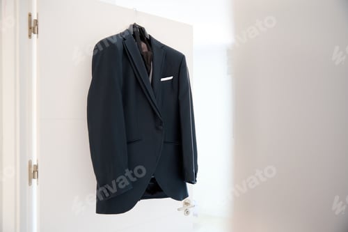 Preview: Wedding suit on a hanger in a hotel room