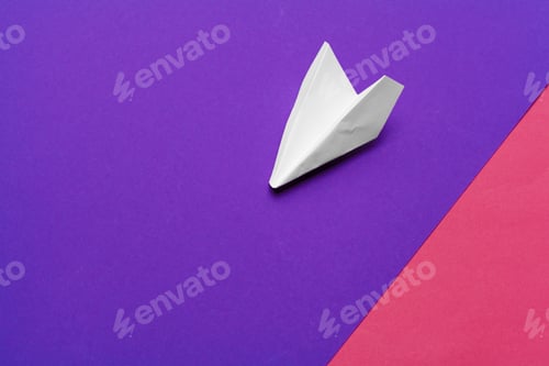 Preview: white paper airplane on a color block paper background. Creative photo