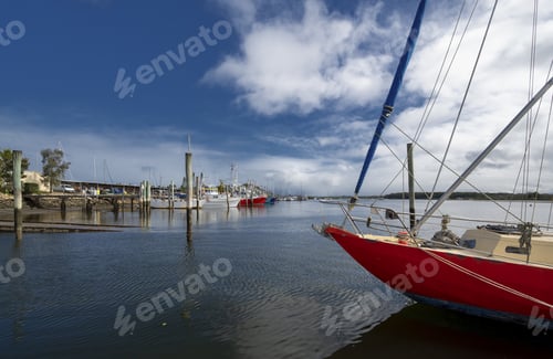 Preview: Eye-level shot of sailboats in a port under the blue sky in Tin Can Bay, Queensland, Australia