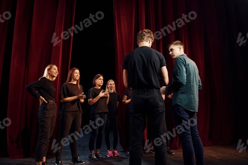 Preview: Group of actors in dark colored clothes on rehearsal in the theater