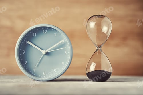 Preview: Hourglass and alarm clock on desk, closeup