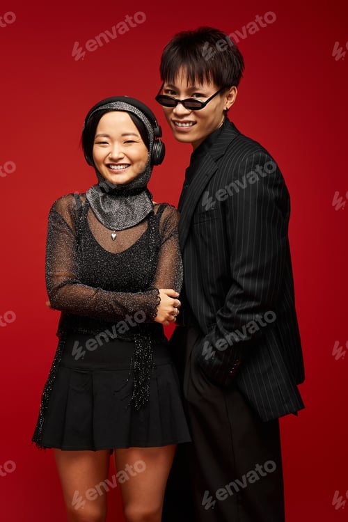 Preview: Stylish couple sharing love and joy against a vibrant red backdrop during a chic evening event