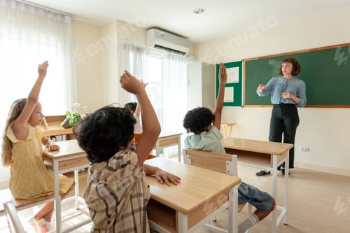 Preview: Adorable student learn with teacher in classroom at elementary school.