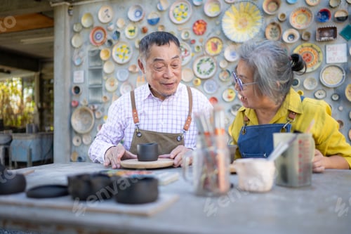 Preview: Asian retired couple is engaged in pottery making and clay painting activities.