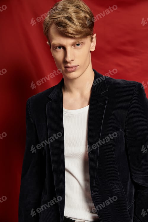 Preview: Young man embodies modern masculinity with stylish flair against a bold backdrop