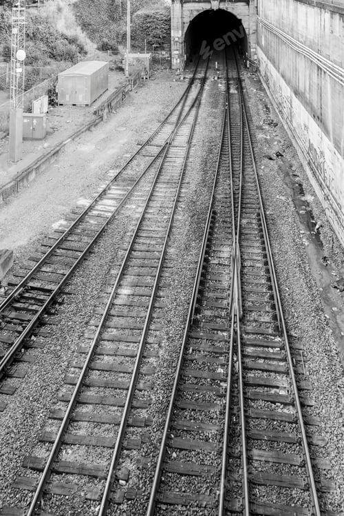 Preview: Empty train tracks leading into dark tunnel.