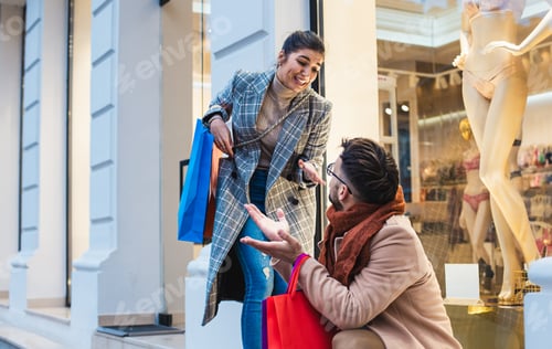 Preview: Man sitting nervously while a happy woman in shopping looking at him.