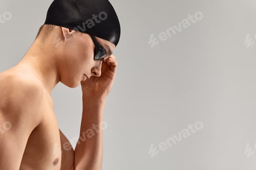 Preview: Young athletic man ready to jump into swimming pool against gray background. The concept of swimming