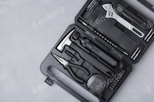Preview: Toolbox with a variety of tools including a hammer, pliers, and a wrench on grey stone background