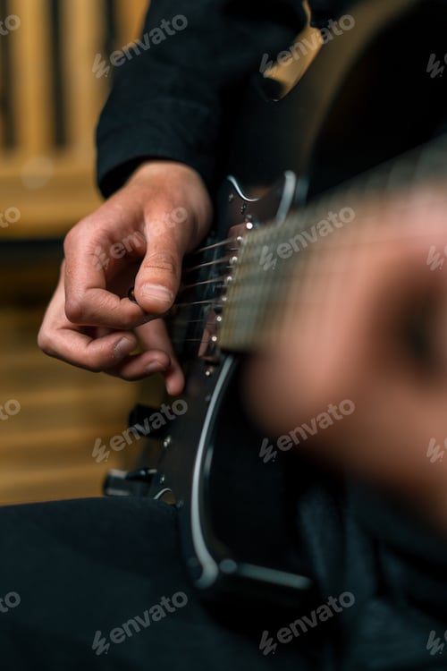 Preview: rock performer with electric guitar in recording studio creating song musical instrument strings