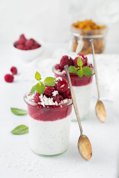Preview: Layered raspberry smoothies with chia seeds, fresh raspberry and coconut on a light stone background