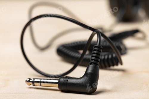 Preview: Black headphones with wire on wooden background