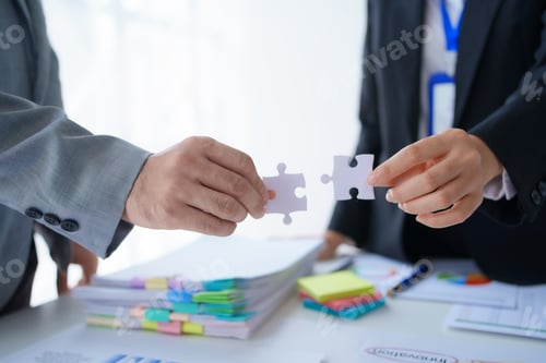 Preview: Group of business people holding jigsaw puzzles, team solving puzzles, planning together.