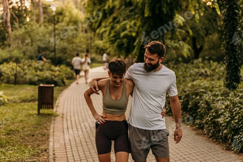 Preview: Happy couple walking and talking in park after exercising