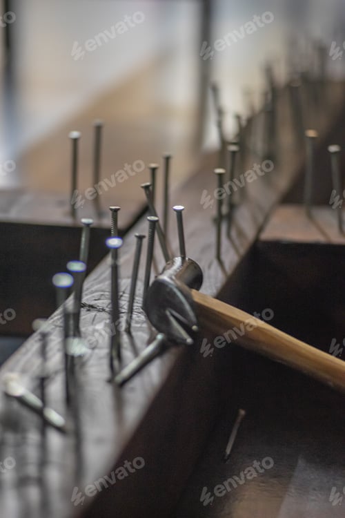Preview: Vertical shot of a vintage claw hammer next to panel pin nails