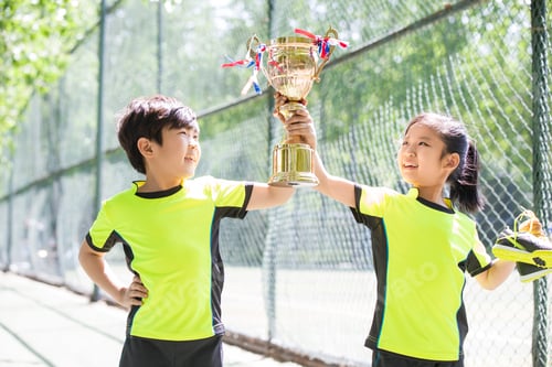 Preview: Happy children in sportswear showing their trophy