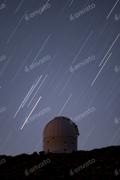 Preview: Vertical shot of an observatory under a night sky with falling stars