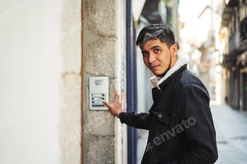 Preview: Latino man ringing a building doorbell