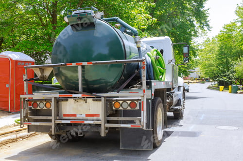 Preview: Vacuum waste truck on the cleaning process portable bio toilet cabins at the construction
