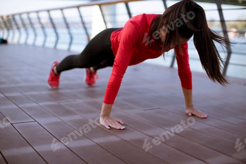 Preview: Young woman exercises on the promenade after running