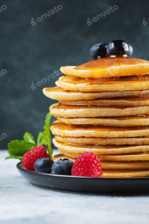 Preview: Delicious pancakes, with fresh blueberries, raspberry and maple syrup or honey on a dark background