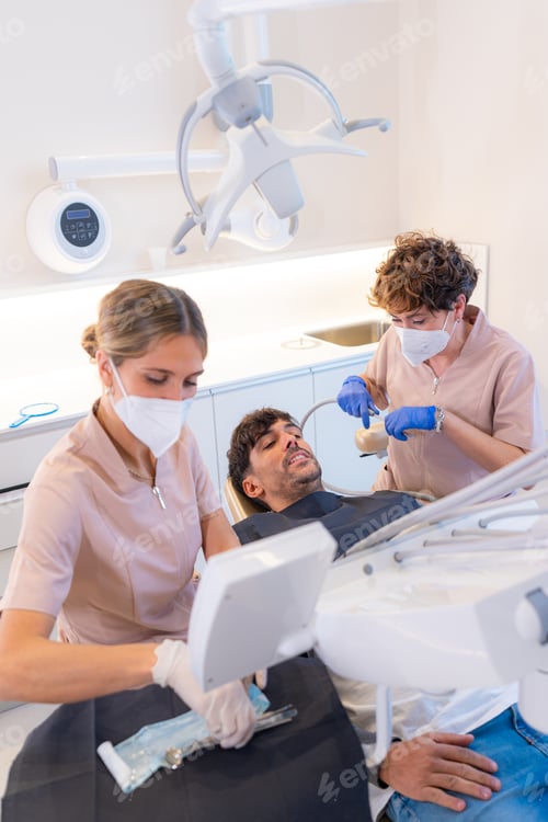 Preview: Man lying while checking the teeth at the dentist office