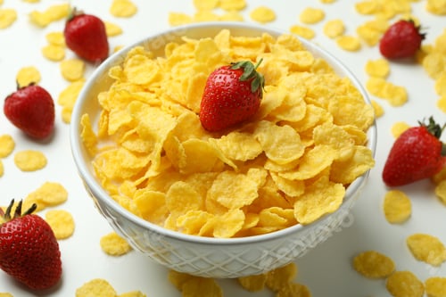 Preview: Concept of tasty breakfast with cornflakes and strawberry on white background
