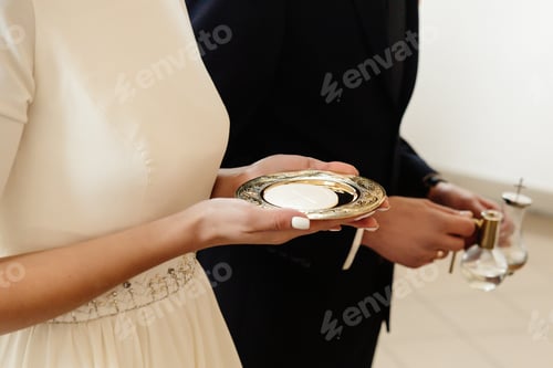 Preview: hands of bride and groom preparing for communion at wedding ceremony in church