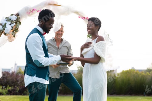 Preview: Happy african american couple holding hands during wedding