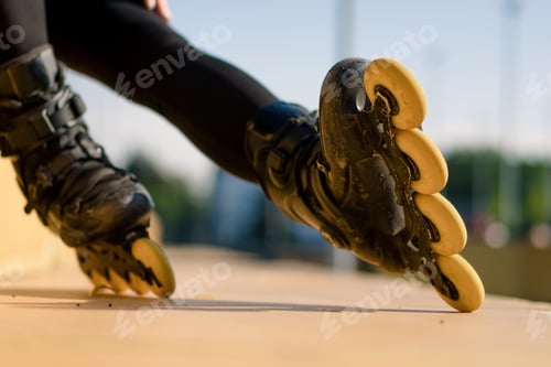Preview: sporty girl rides roller skates in park on city background Active girl in enjoys roller skating