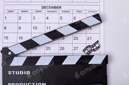 Preview: Calendar december with mark on 28 day and cinema clapperboard.