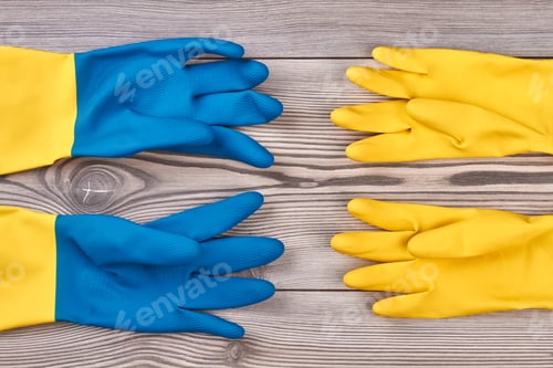 Preview: Colorful rubber gloves on wooden background.