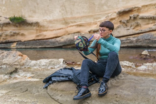 Preview: Seated woman taking a pen from a backpack