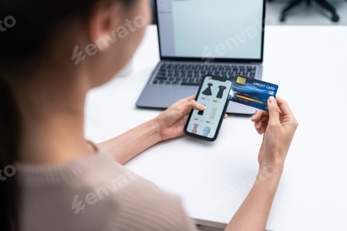Preview: Asian young woman using mobile phone for shopping sell online at home.
