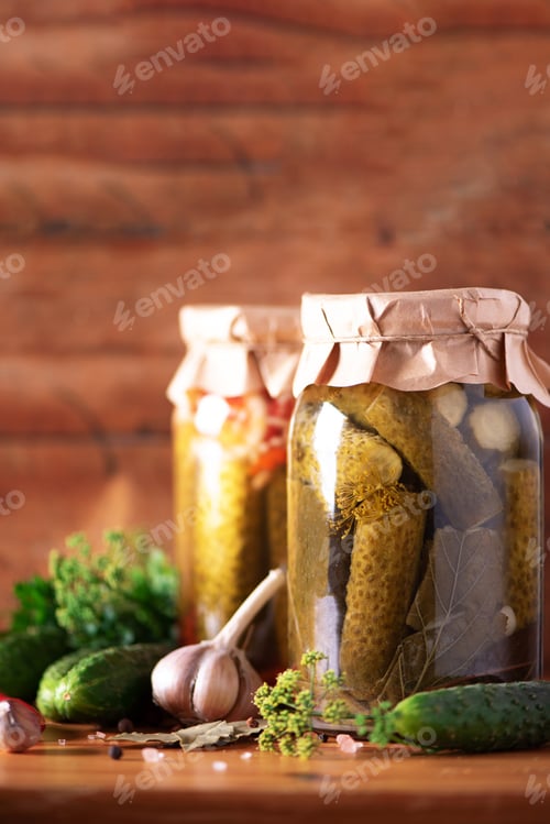 Preview: Canned gherkins in jar, fresh dill, garlic, pepper over wooden background. Copy space. Harvest