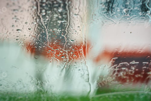 Preview: Rain water drops on the window with a blurred bckground