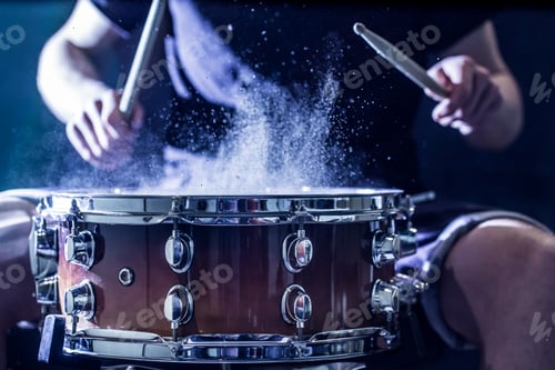 Preview: Man plays musical percussion instrument with sticks.