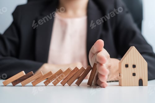 Preview: Businessman stop falling wooden blocks and protect house model. Crisis, fall Business, Risk, Economi