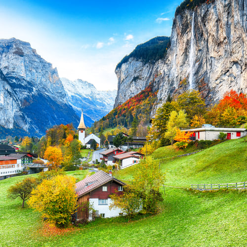 Preview: autumn landscape of alpine village Lauterbrunnen with famous church and Staubbach waterfall