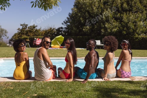 Preview: Diverse group of friends smiling and sitting at the poolside