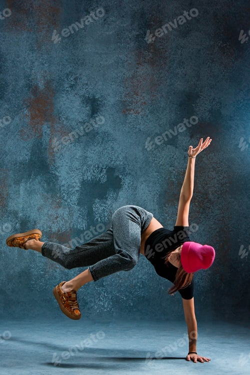 Preview: Young girl break dancing on wall background.