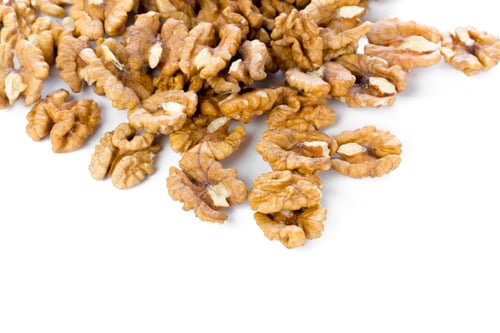 Preview: Walnuts scattered on a white surface ready for cooking or snacking purposes