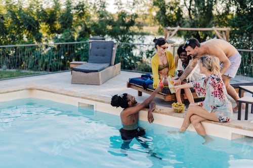 Preview: Friends toasting drinks at poolside summer party