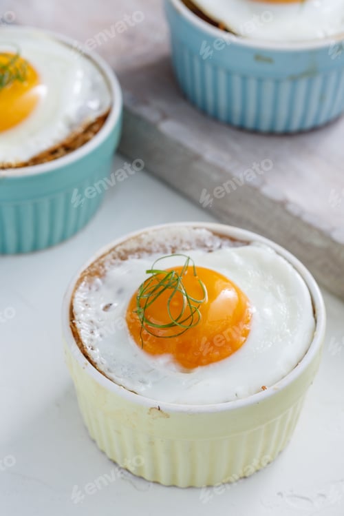 Preview: Baked eggs in ramekins close view, selective focus